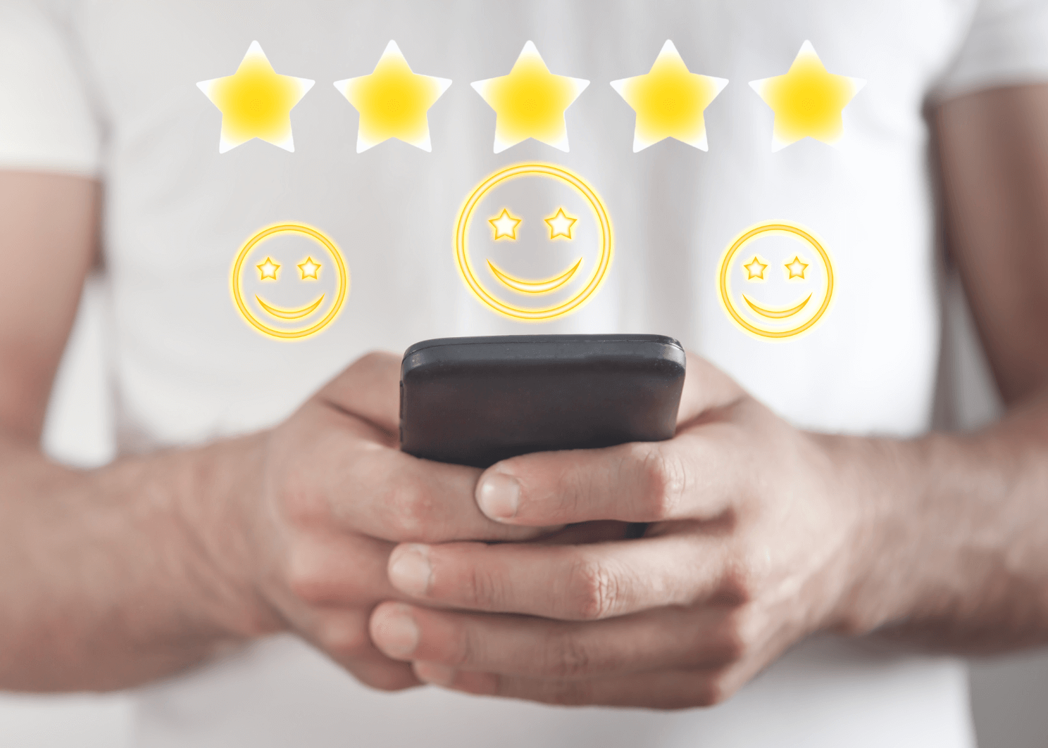 A person holding a smartphone with five yellow stars above three yellow smiley icons.