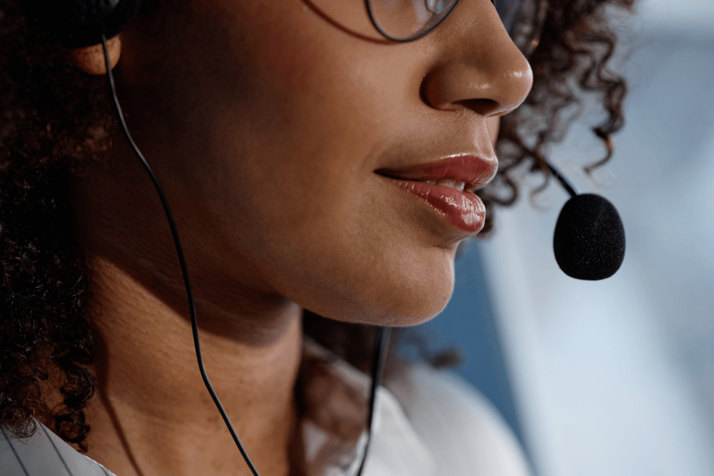 Close-up of a woman wearing a headset with a microphone near her mouth.